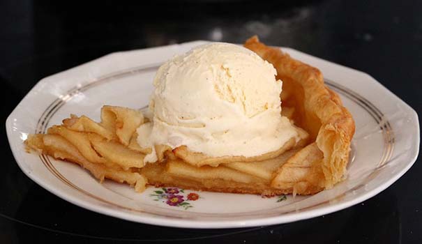 A plate with a slice of apple pie and a scoop of vanilla ice cream