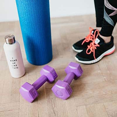 Espresso Health Benefits: An image featuring two dumbbells, water container, yoga mat and feet of a person wearing rubber shoes