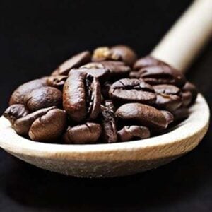 Health Benefits of Espresso: Coffee beans scooped using a wood spoon