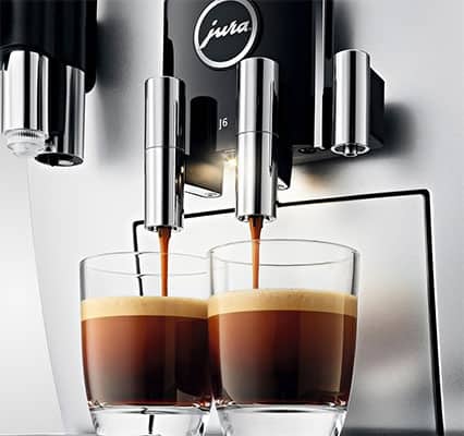 Coffee dripping from the 2 coffee spouts of the Impressa J6 into 2 glasses