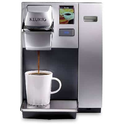 Keurig K155 Coffee Maker with coffee dripping from its spout into a white cup
