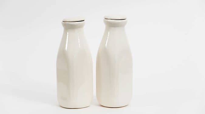 two white ceramic bottles of milk with lid