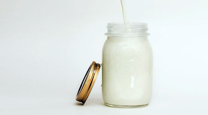 milk in a jar with a gold lid and white paper straw