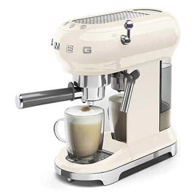 Smeg Espresso Machine with cream exterior and a tall glass of cappuccino on the drip tray